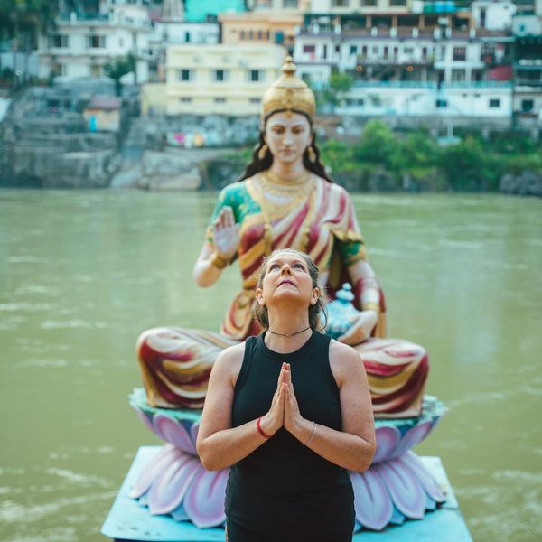 Person meditating peacefully outdoors with a serene natural background.